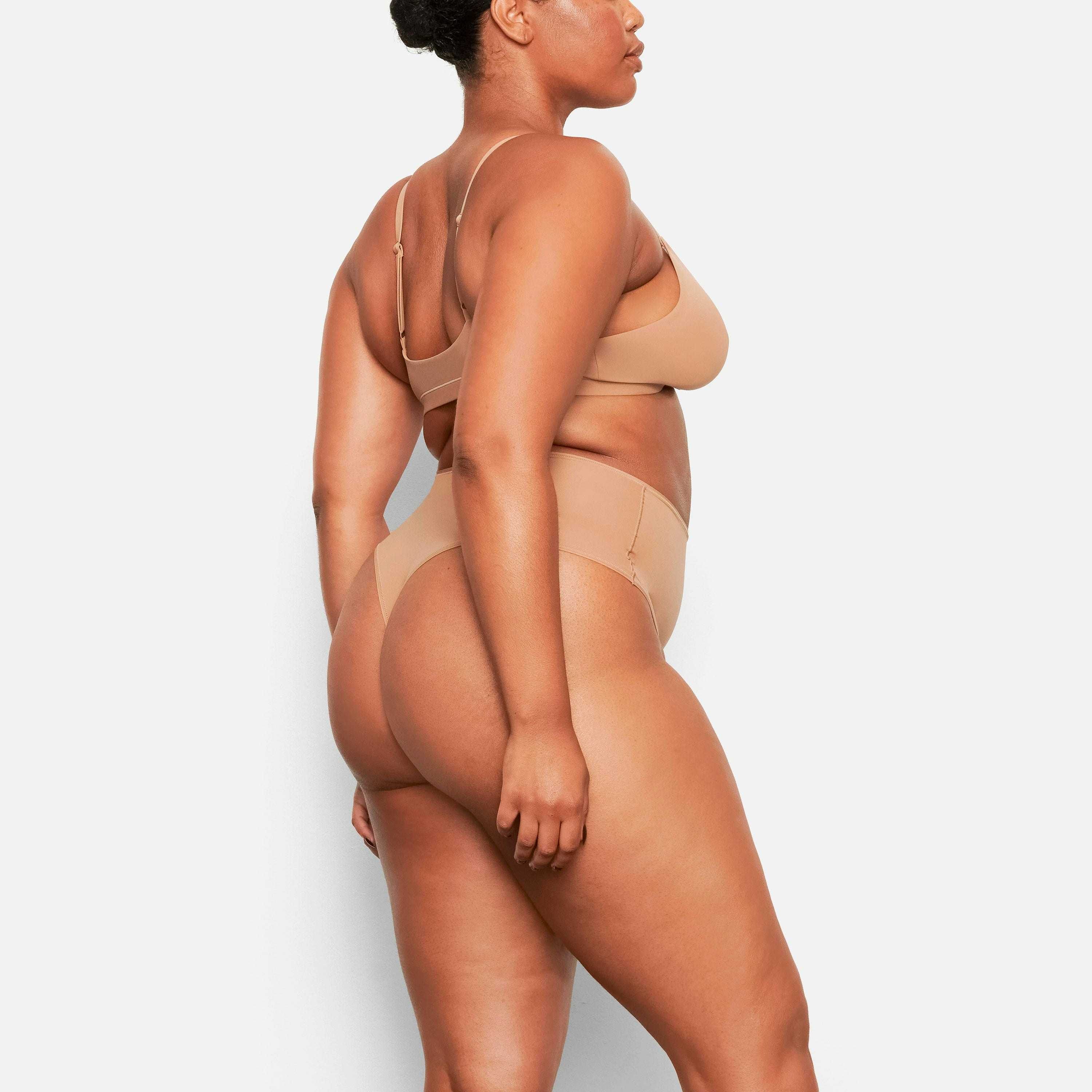 A MODEL STANDS SIDEWAYS SHOWING THE PROFILE OF THE FITS EVERYBODY HIGH WAISTED THONG | SIENNA