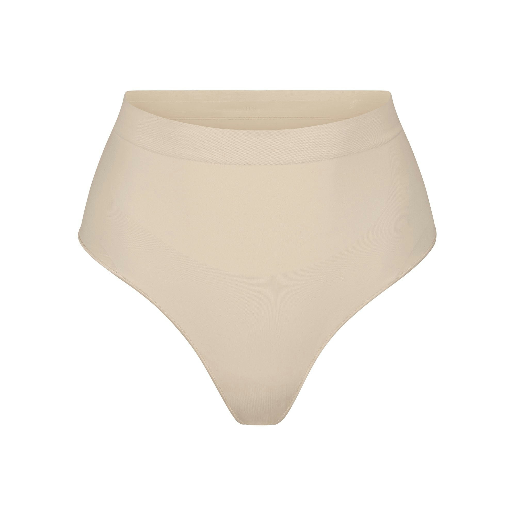 SEAMLESS SCULPT MID WAIST THONG | SAND (SHAPEWEAR THONGS, PANTIES) LAYS FLAT ON A WHITE BACKGROUND | FLT