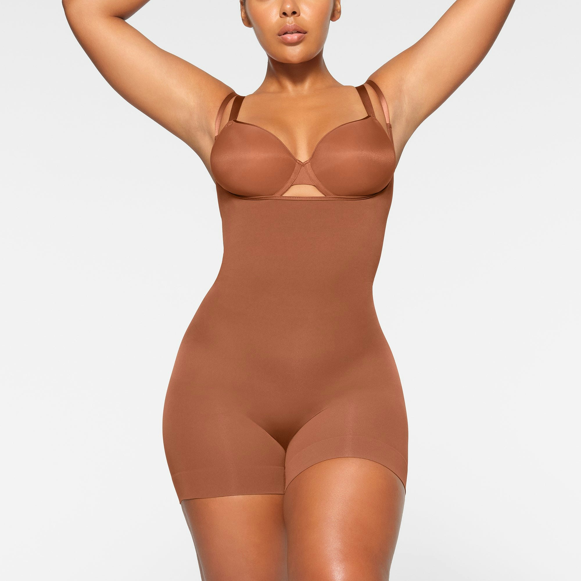 SEAMLESS SCULPT OPEN BUST SHORTIE BODYSUIT WORN BY A MODEL IN FRONT VIEW | SEE: M, L, XL