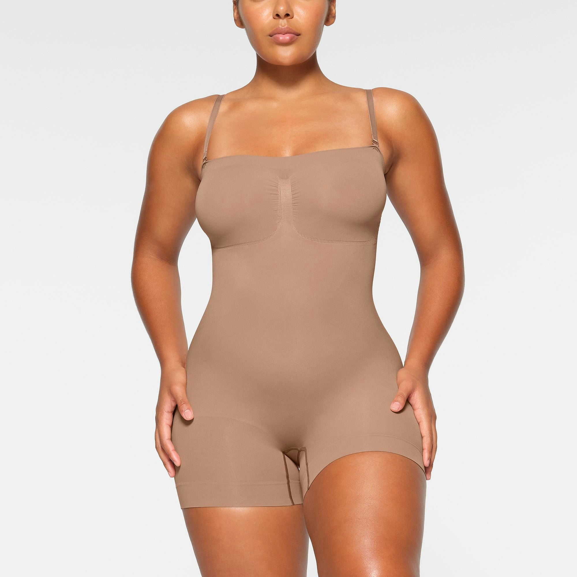 SEAMLESS SCULPT STRAPLESS MID THIGH BODYSUIT WORN BY A MODEL IN FRONT VIEW