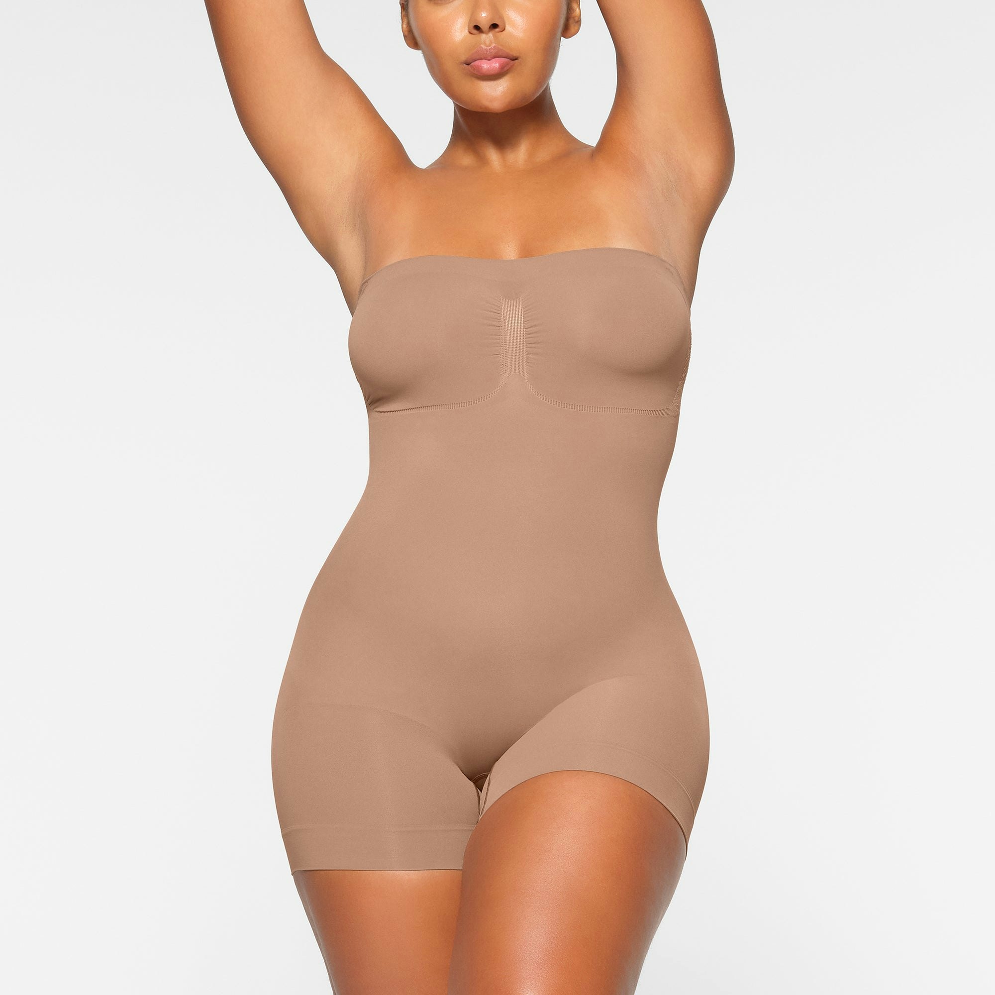 SEAMLESS SCULPT STRAPLESS MID THIGH BODYSUIT WORN BY A MODEL IN FRONT VIEW | SEE: M, L, XL
