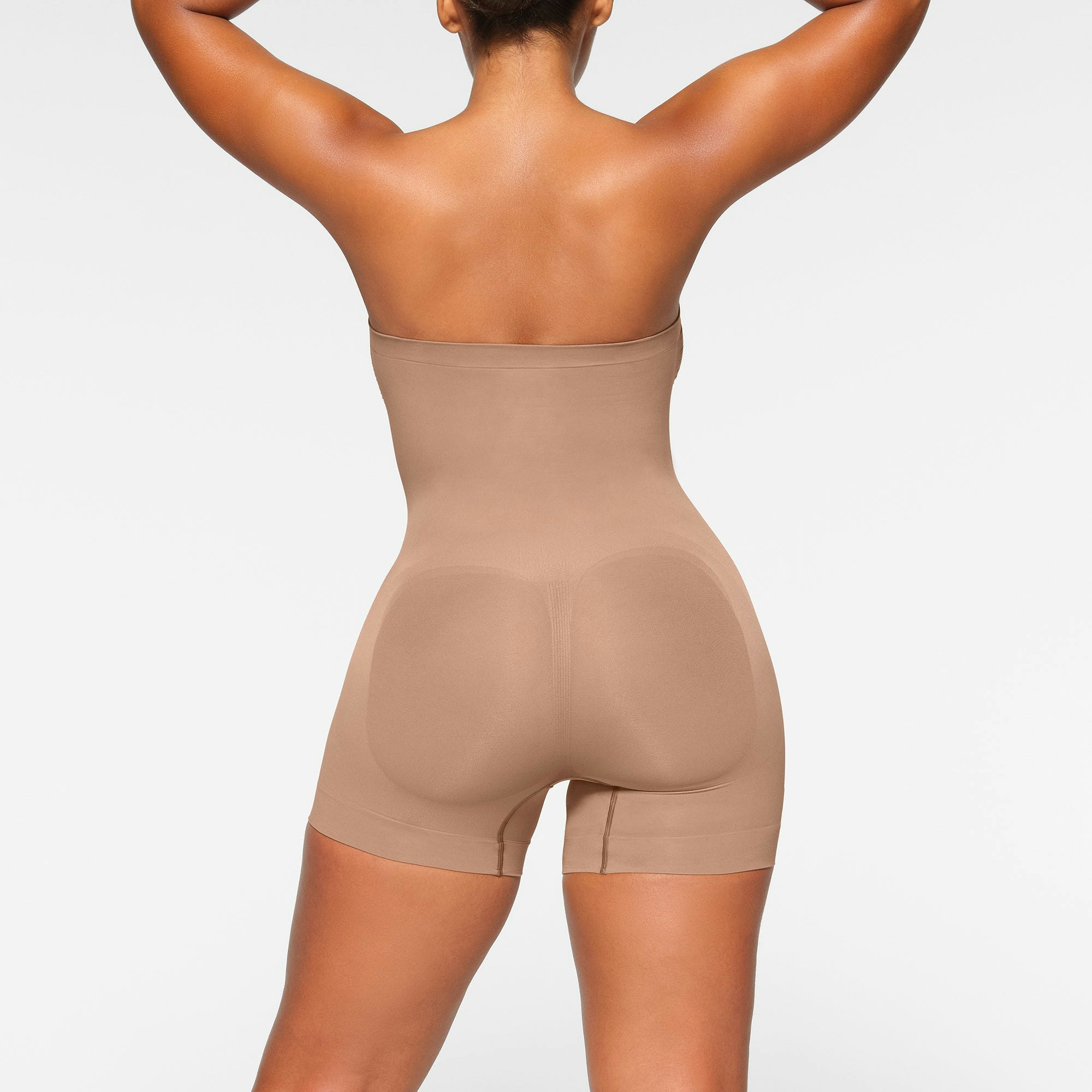 SEAMLESS SCULPT STRAPLESS MID THIGH BODYSUIT ON A MODEL BACK VIEW