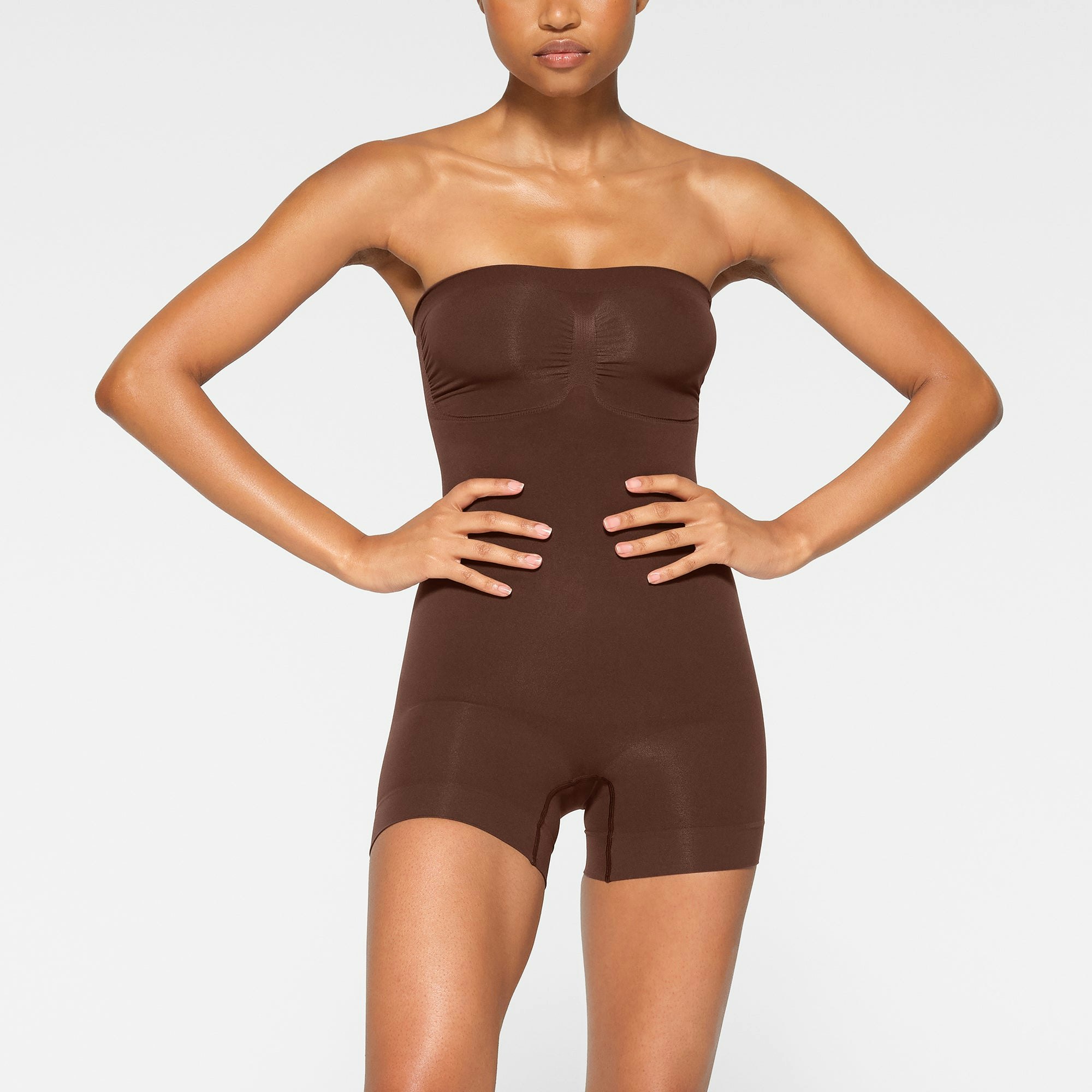 SEAMLESS SCULPT STRAPLESS MID THIGH BODYSUIT WORN BY A MODEL IN SIDE VIEW