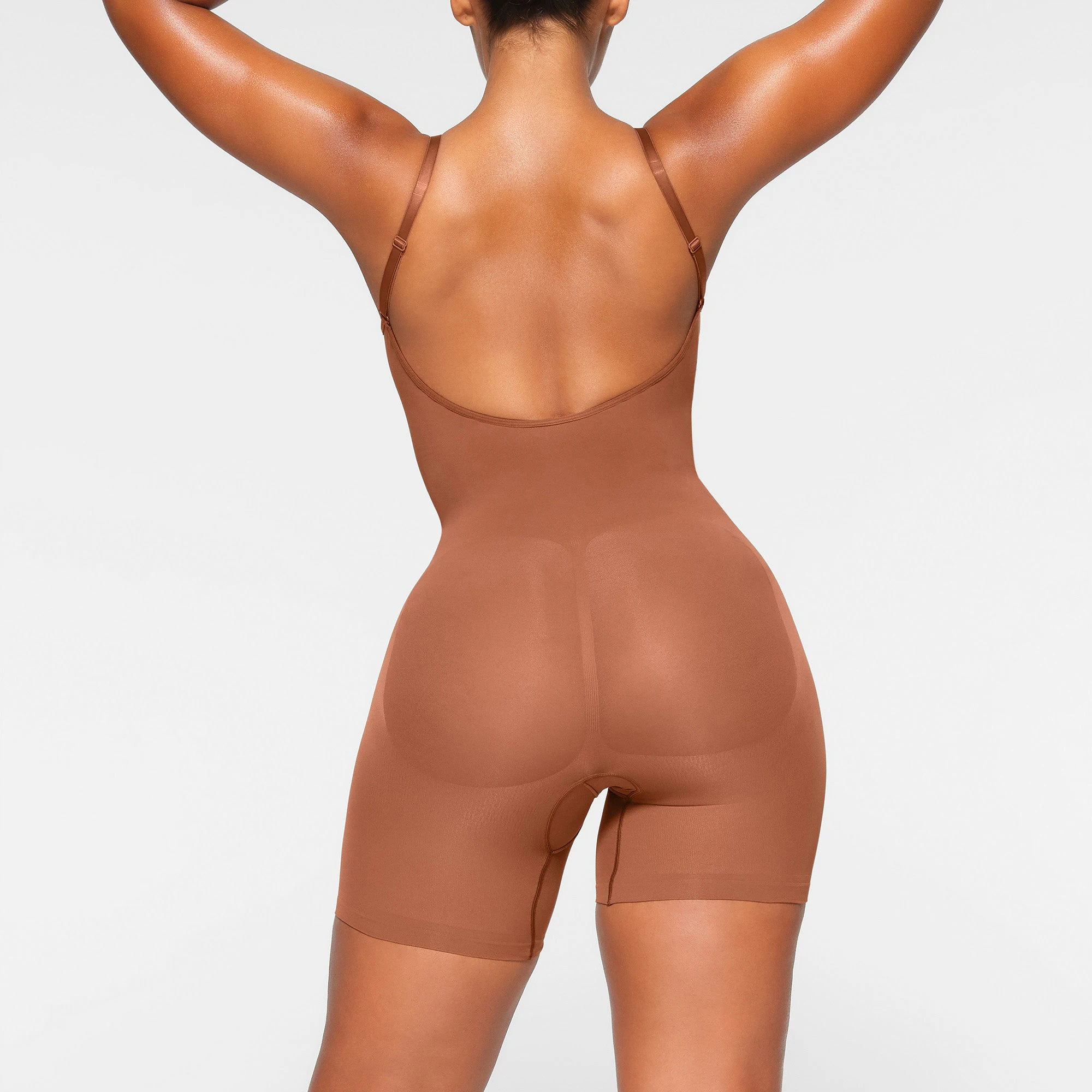 SEAMLESS SCULPT LOW BACK MID THIGH BODYSUIT WORN BY A MODEL IN SIDE VIEW