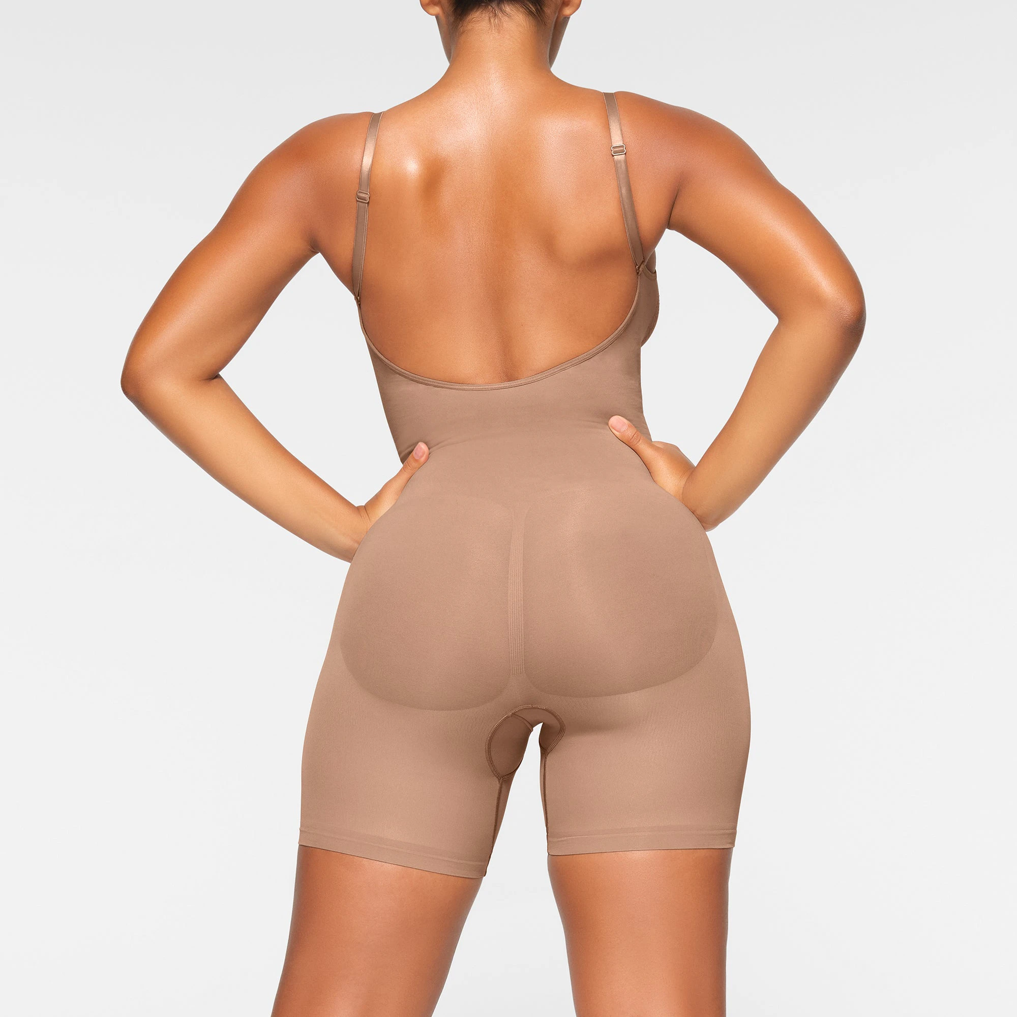 SEAMLESS SCULPT LOW BACK MID THIGH BODYSUIT WORN BY A MODEL IN SIDE VIEW