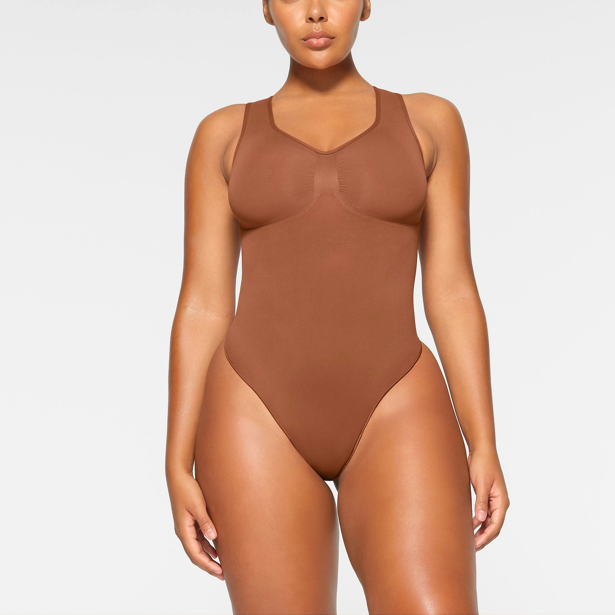 SEAMLESS SCULPT SCOOP NECK THONG BODYSUIT WORN BY A MODEL IN FRONT VIEW | SEE: M, L, XL
