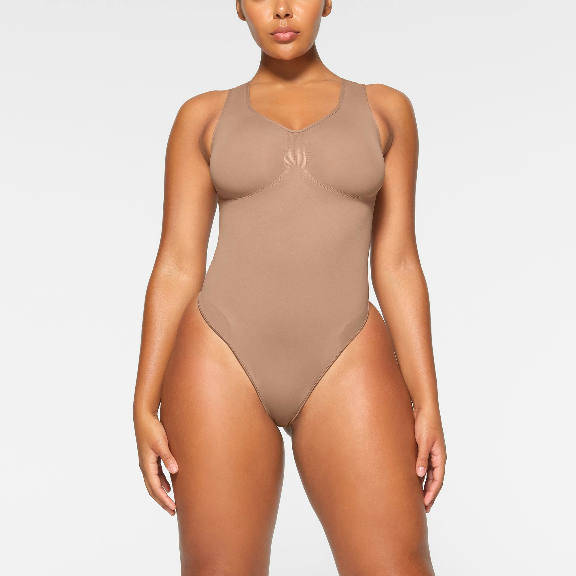 SEAMLESS SCULPT SCOOP NECK THONG BODYSUIT WORN BY A MODEL IN FRONT VIEW | SEE: M, L, XL