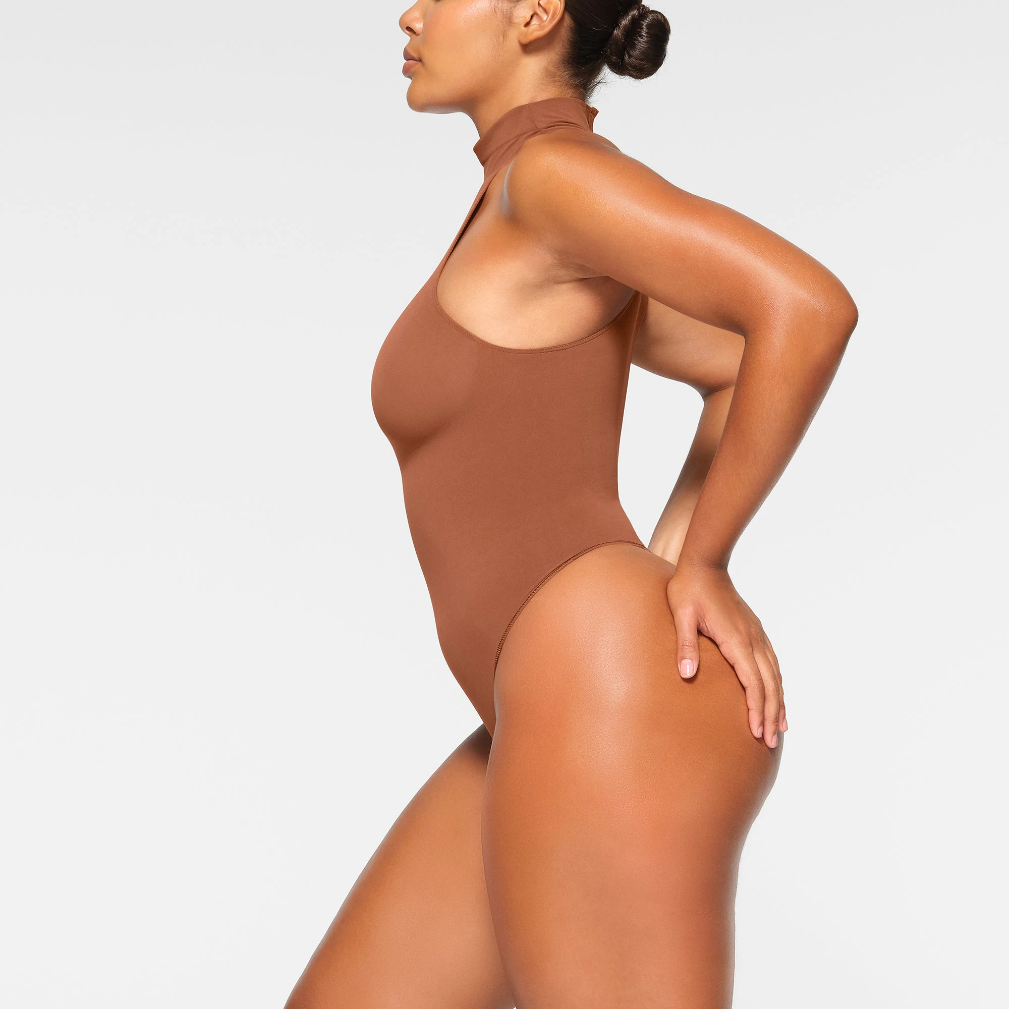 SEAMLESS SCULPT HIGH NECK THONG BODYSUIT WORN BY A MODEL IN SIDE VIEW