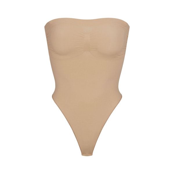 SEAMLESS SCULPT STRAPLESS THONG BODYSUIT | CLAY (SHAPEWEAR BODYSUITS) LAYS FLAT ON A WHITE BACKGROUND | FLT