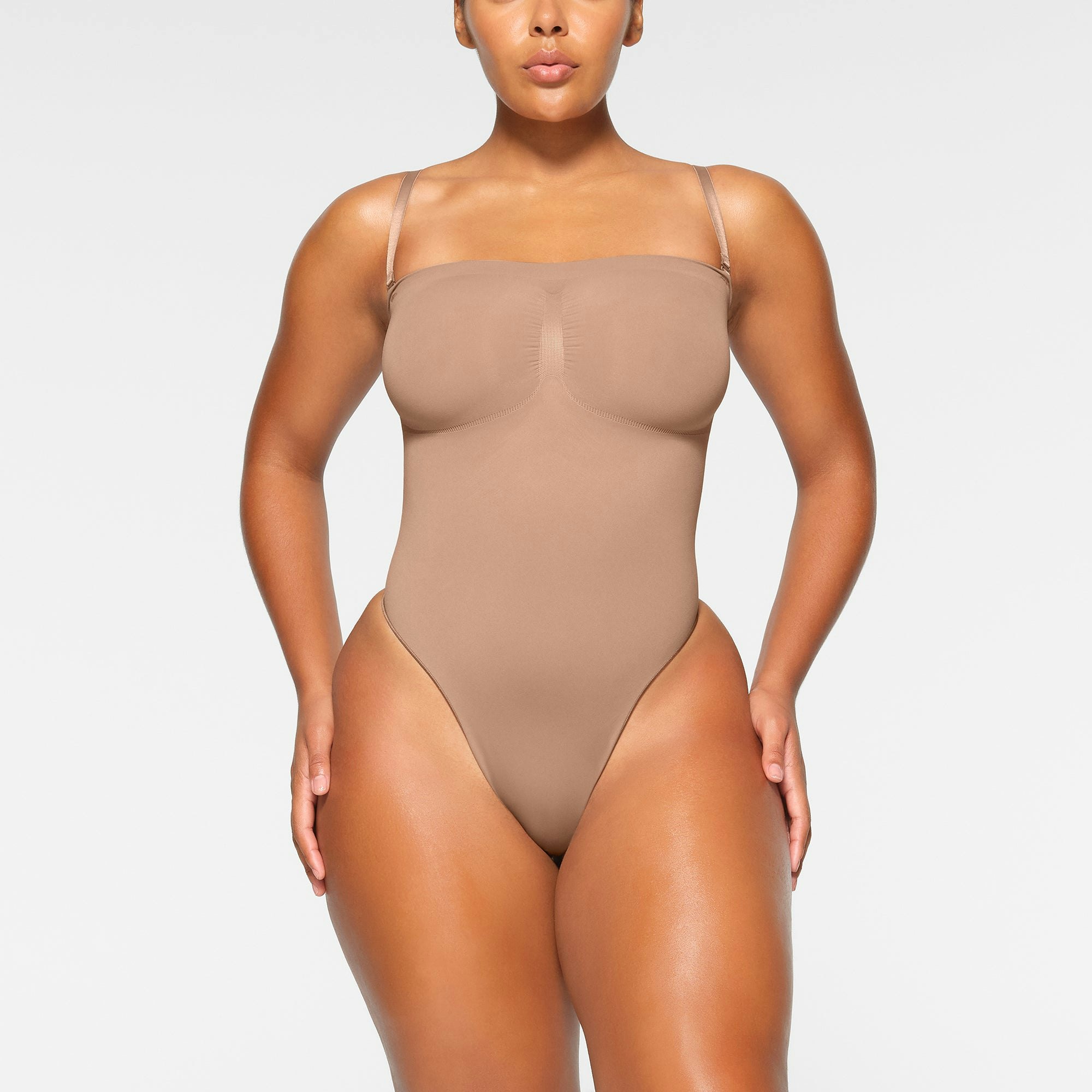 SEAMLESS SCULPT STRAPLESS THONG BODYSUIT WORN BY A MODEL IN FRONT VIEW