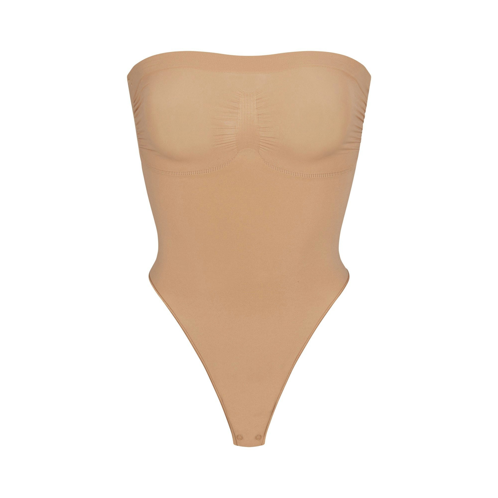 SEAMLESS SCULPT STRAPLESS THONG BODYSUIT LAYS FLAT ON A WHITE BACKGROUND