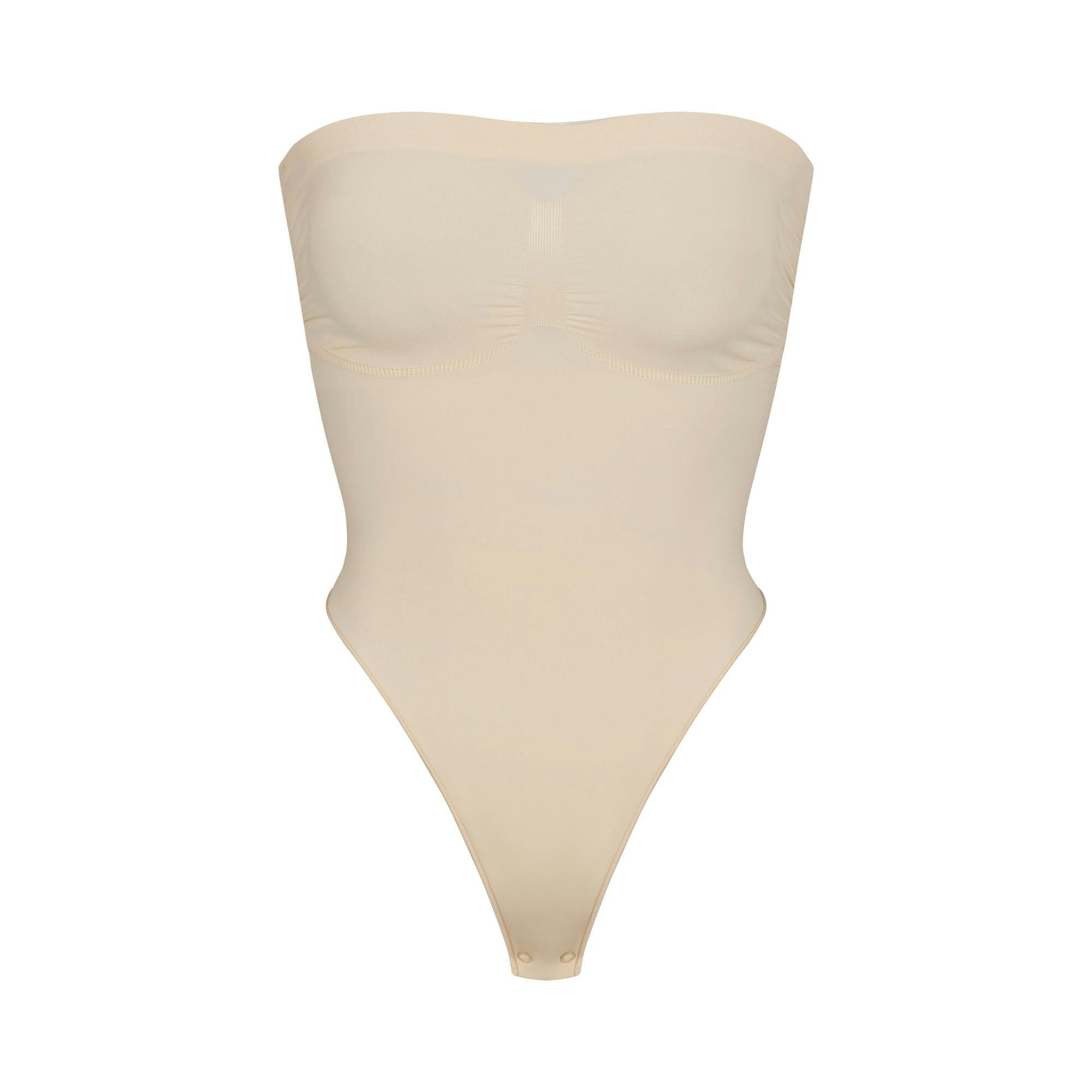 SEAMLESS SCULPT STRAPLESS THONG BODYSUIT | SAND (SHAPEWEAR BODYSUITS) LAYS FLAT ON A WHITE BACKGROUND | FLT
