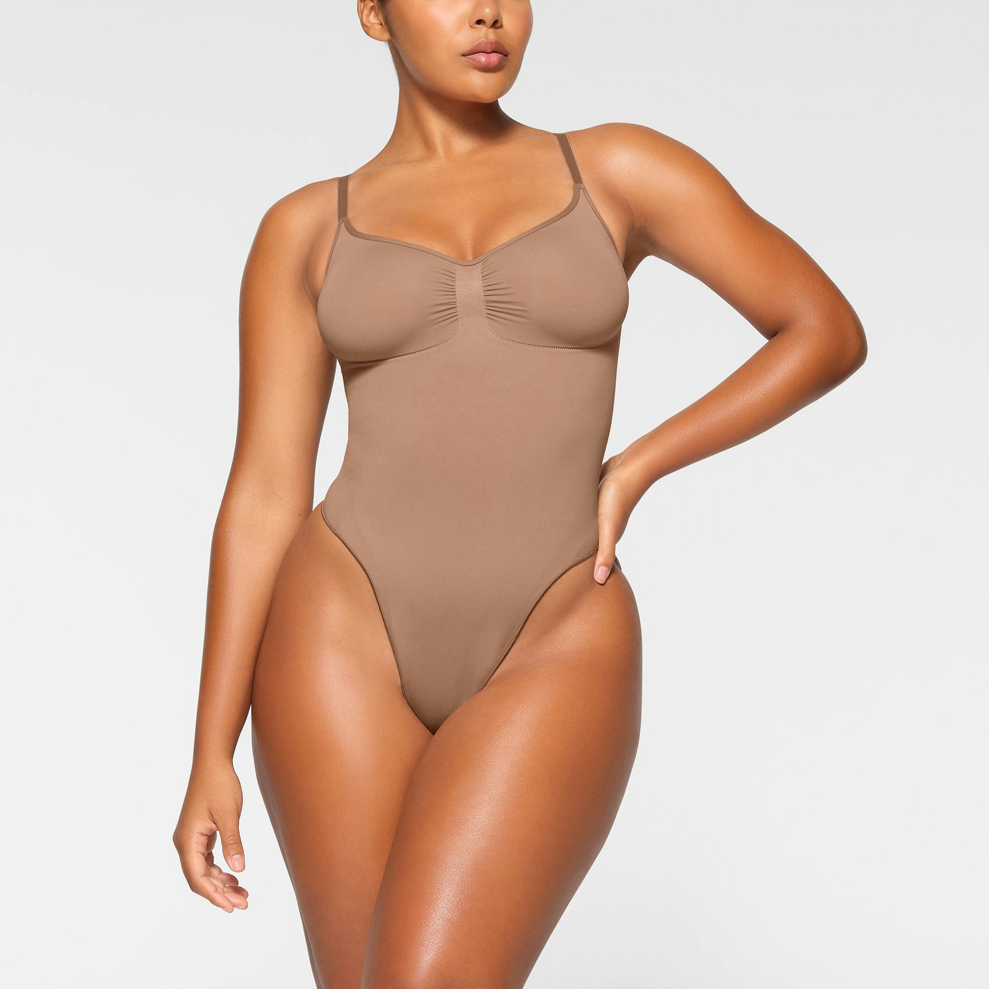 SEAMLESS SCULPT THONG BODYSUIT WORN BY A MODEL IN FRONT VIEW | SEE: M, L, XL