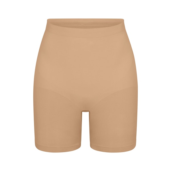 SEAMLESS SCULPT MID THIGH SHORT | CLAY (SHAPEWEAR SHORTS, SHAPEWEAR) LAYS FLAT ON A WHITE BACKGROUND | FLT