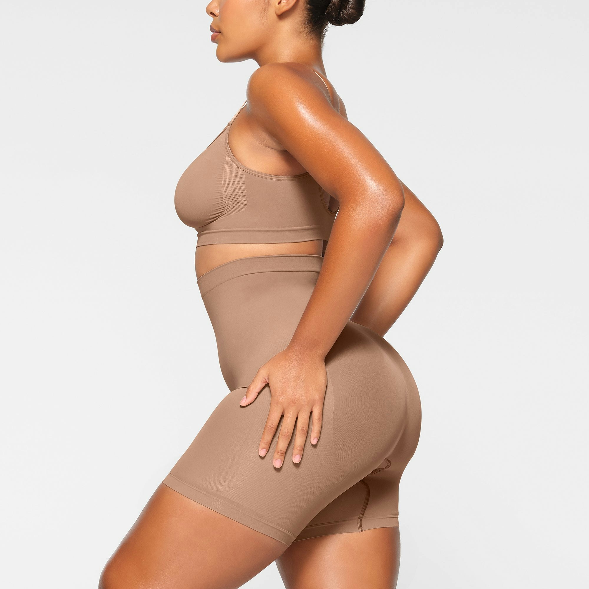 SEAMLESS SCULPT MID THIGH SHORT WORN BY A MODEL IN SIDE VIEW