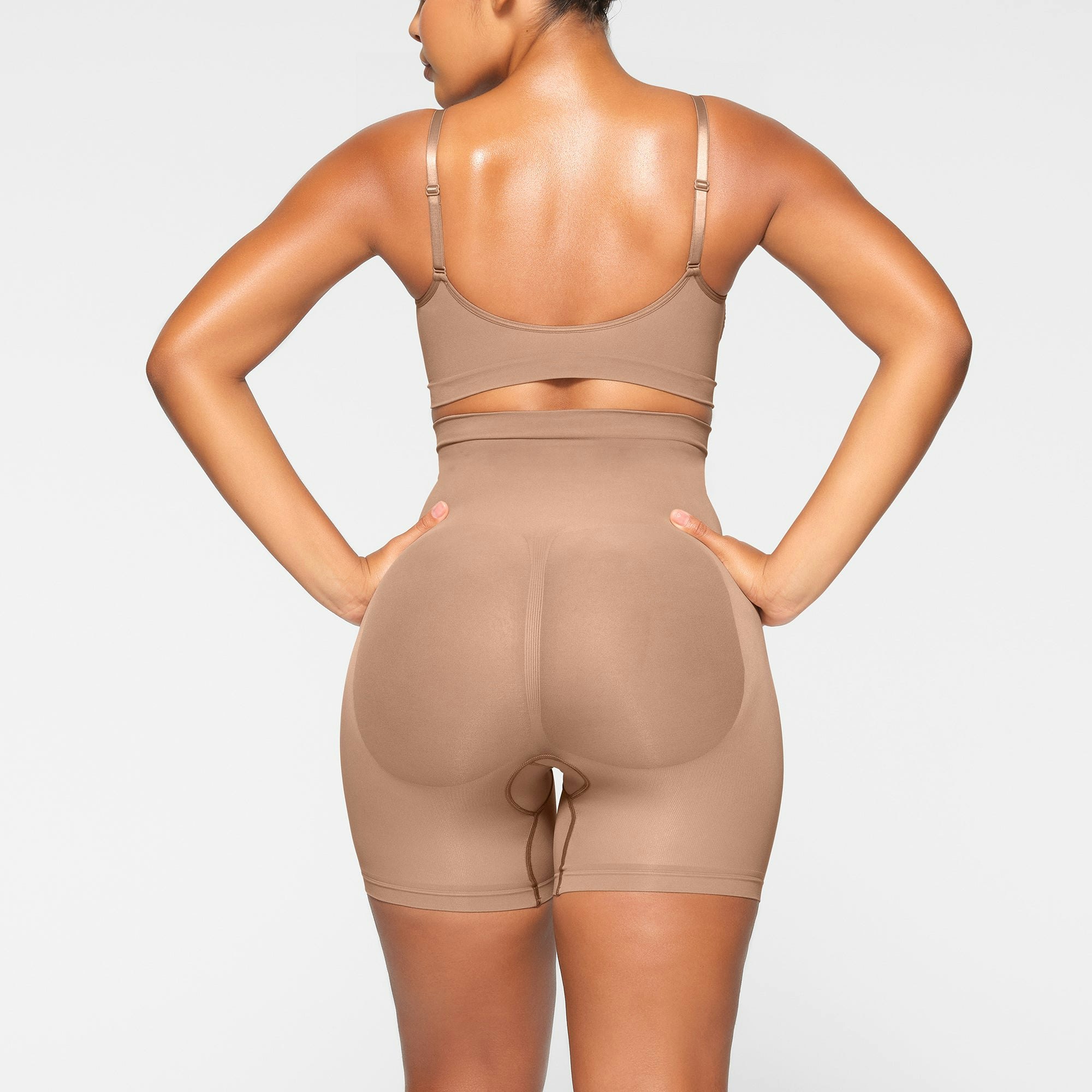 SEAMLESS SCULPT MID THIGH SHORT ON A MODEL BACK VIEW