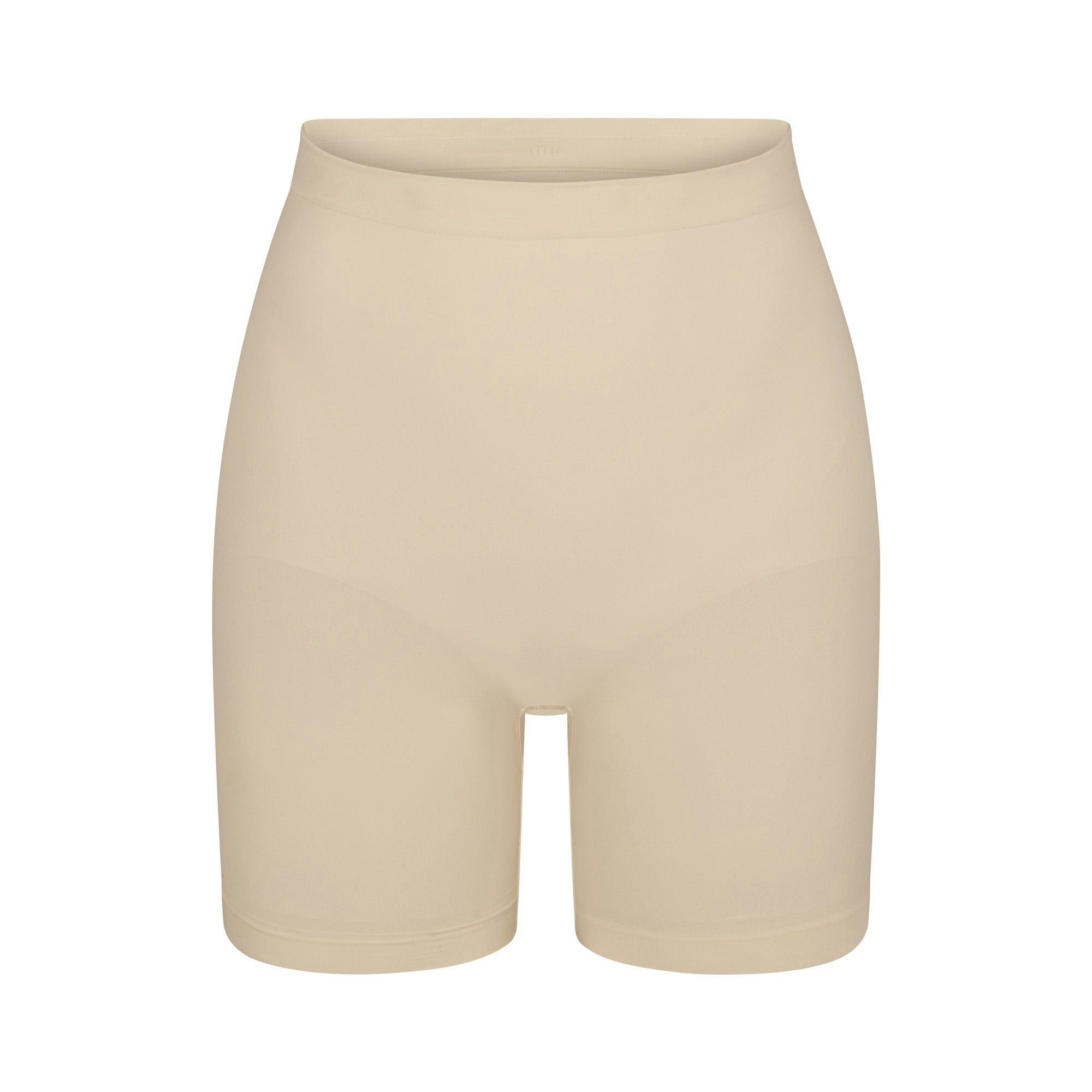 SEAMLESS SCULPT MID THIGH SHORT | SAND (SHAPEWEAR SHORTS, SHAPEWEAR) LAYS FLAT ON A WHITE BACKGROUND | FLT