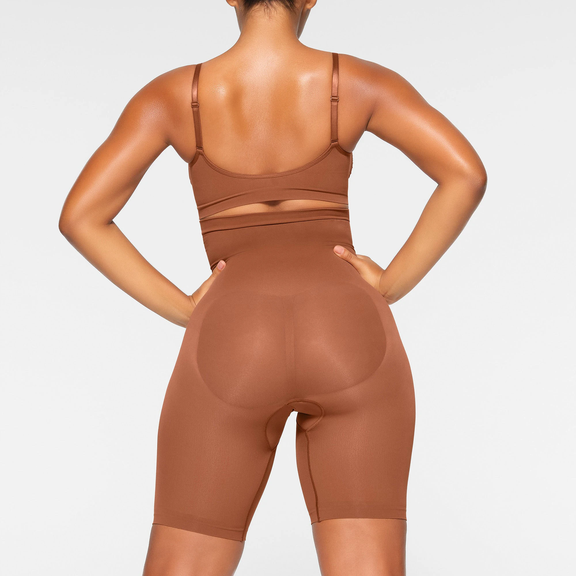 SEAMLESS SCULPT HIGH-WAISTED ABOVE THE KNEE SHORT ON A MODEL BACK VIEW