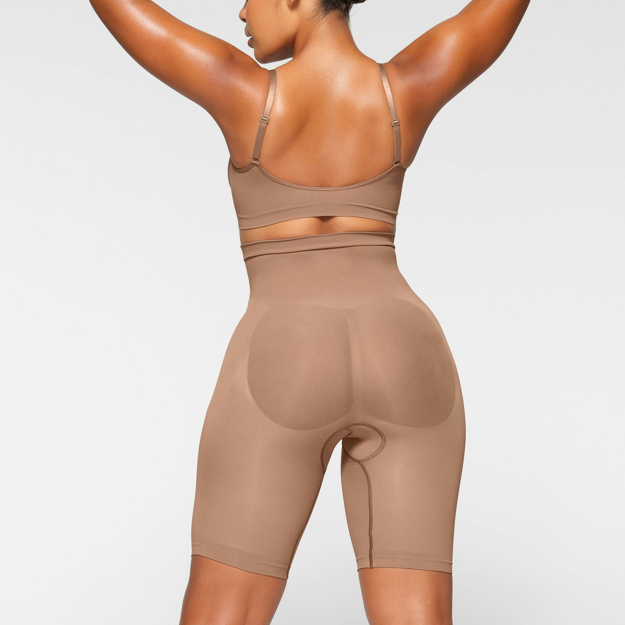 SEAMLESS SCULPT HIGH-WAISTED ABOVE THE KNEE SHORT ON A MODEL BACK VIEW