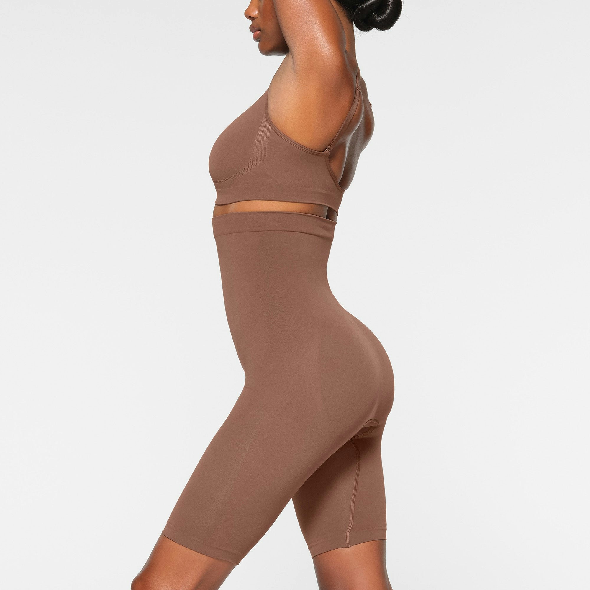 SEAMLESS SCULPT HIGH-WAISTED ABOVE THE KNEE SHORT WORN BY A MODEL IN SIDE VIEW