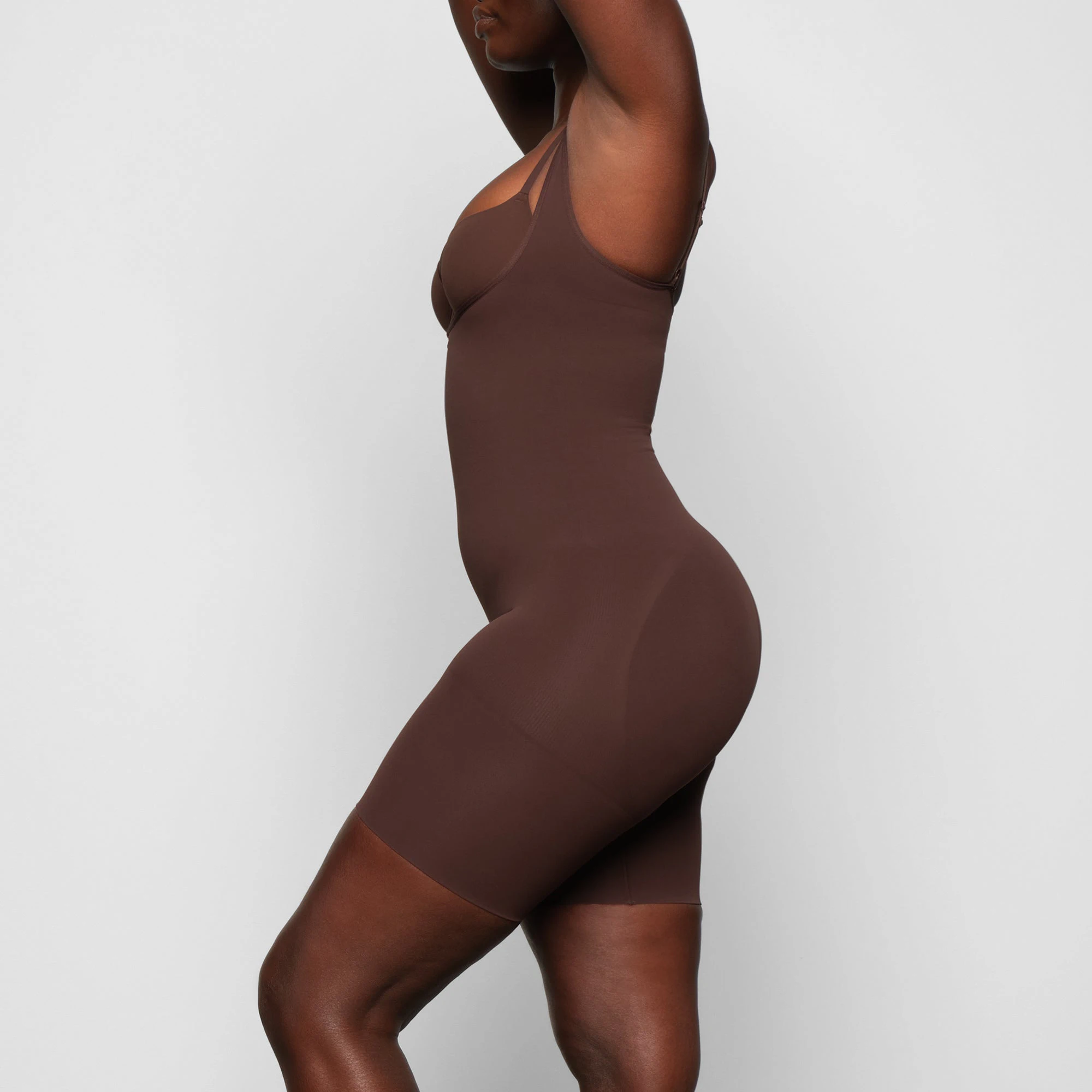 BUTT ENHANCING OPEN BUST BODYSUIT WORN BY A MODEL IN SIDE VIEW