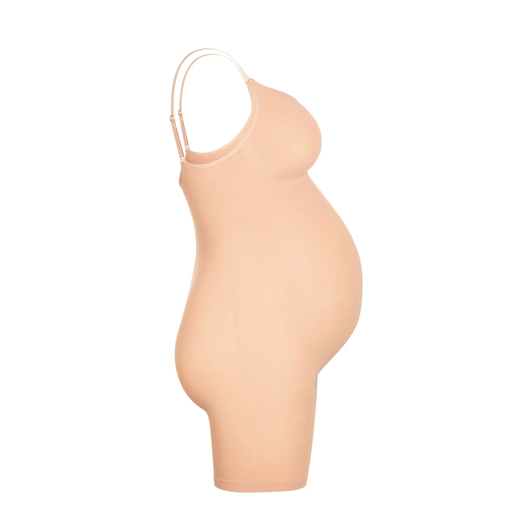 A MODEL STANDS FACING FORWARD WEARING THE MATERNITY SCULPTING BODYSUIT MID THIGH | CLAY