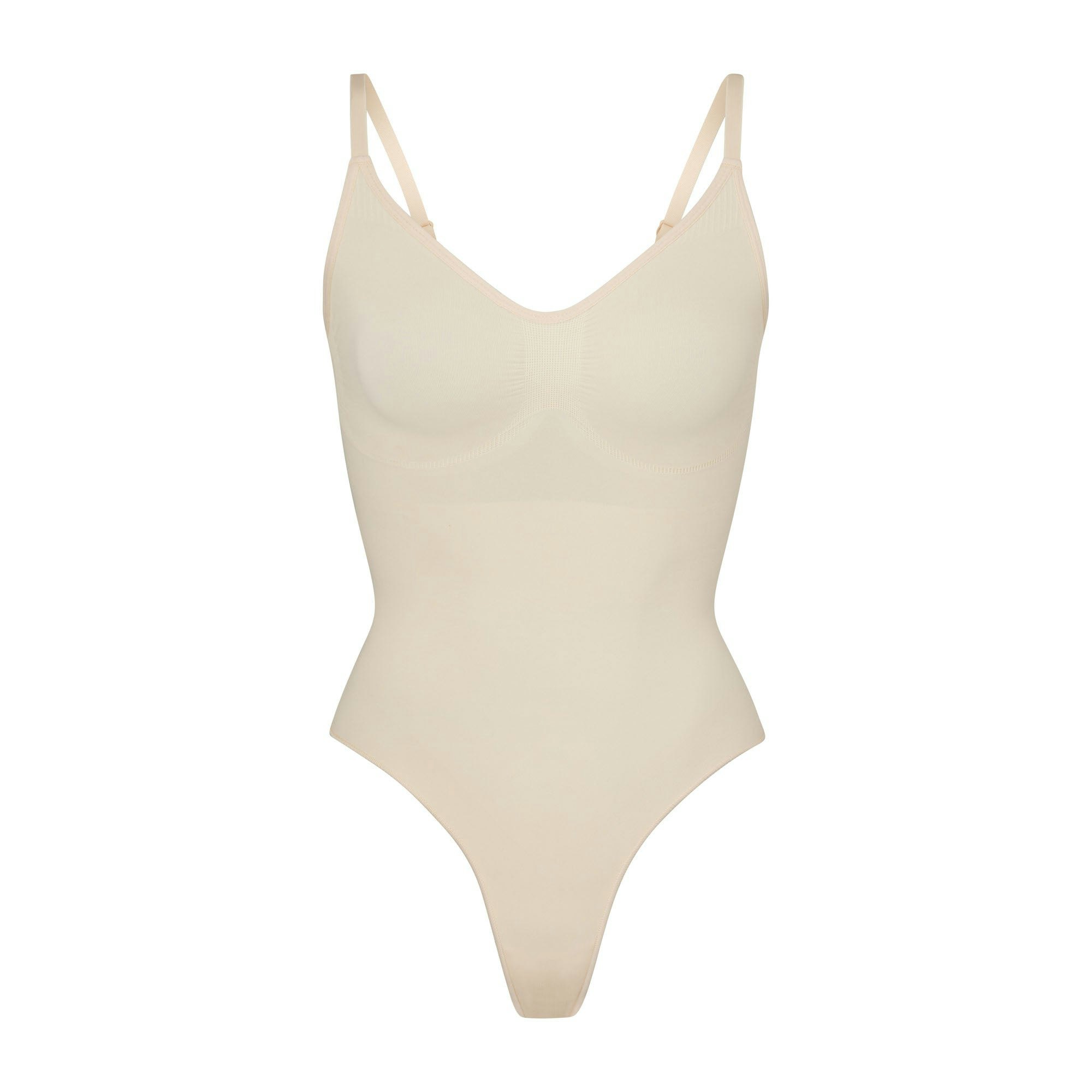 SEAMLESS SCULPT THONG BODYSUIT | SAND (SHAPEWEAR BODYSUITS) LAYS FLAT ON A WHITE BACKGROUND | FLT
