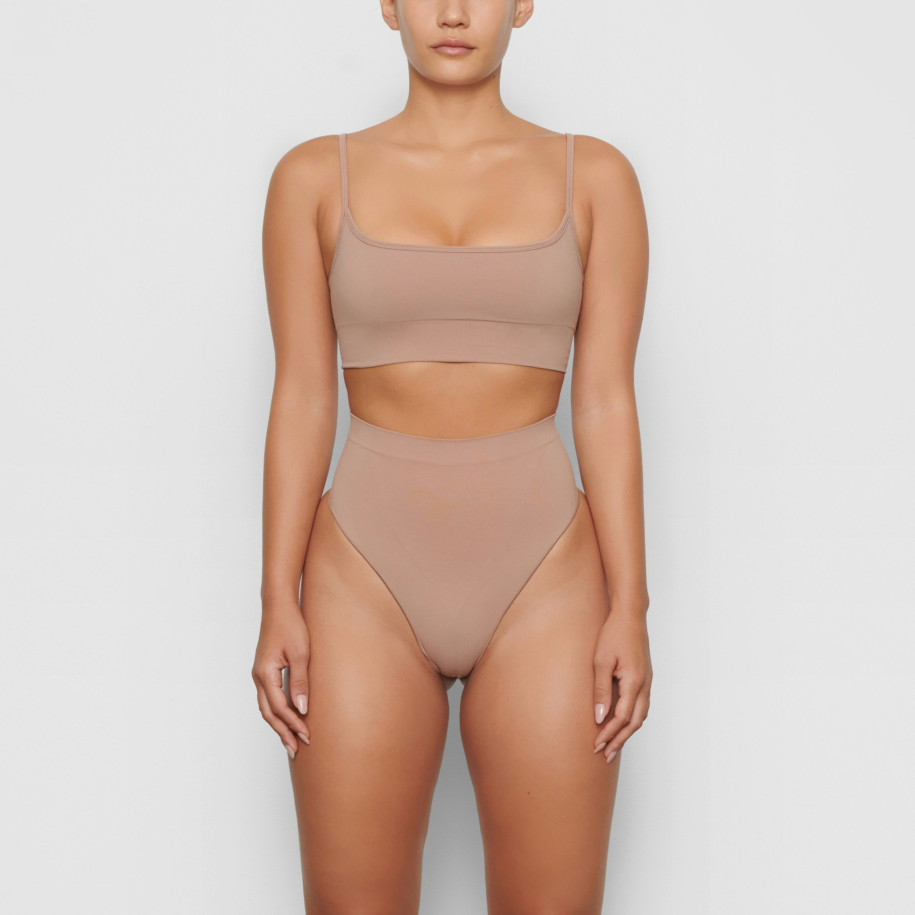 SEAMLESS SCULPT MID WAIST THONG WORN BY A MODEL IN FRONT VIEW | SEE: M, L, XL