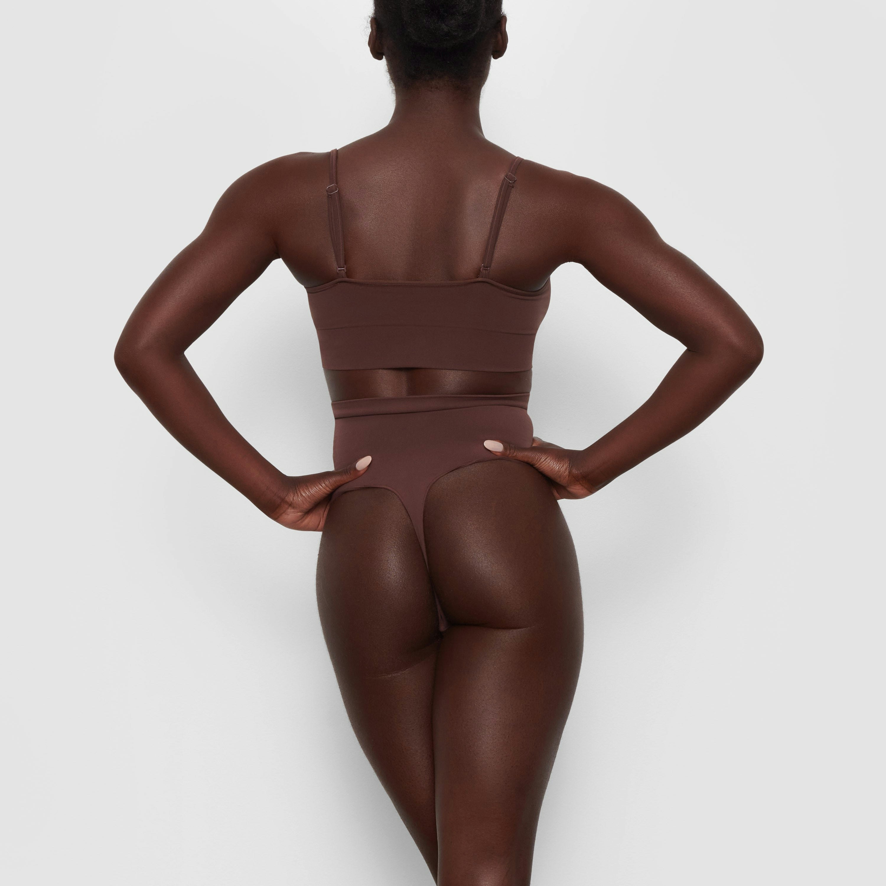 SEAMLESS SCULPT MID WAIST THONG ON A MODEL BACK VIEW