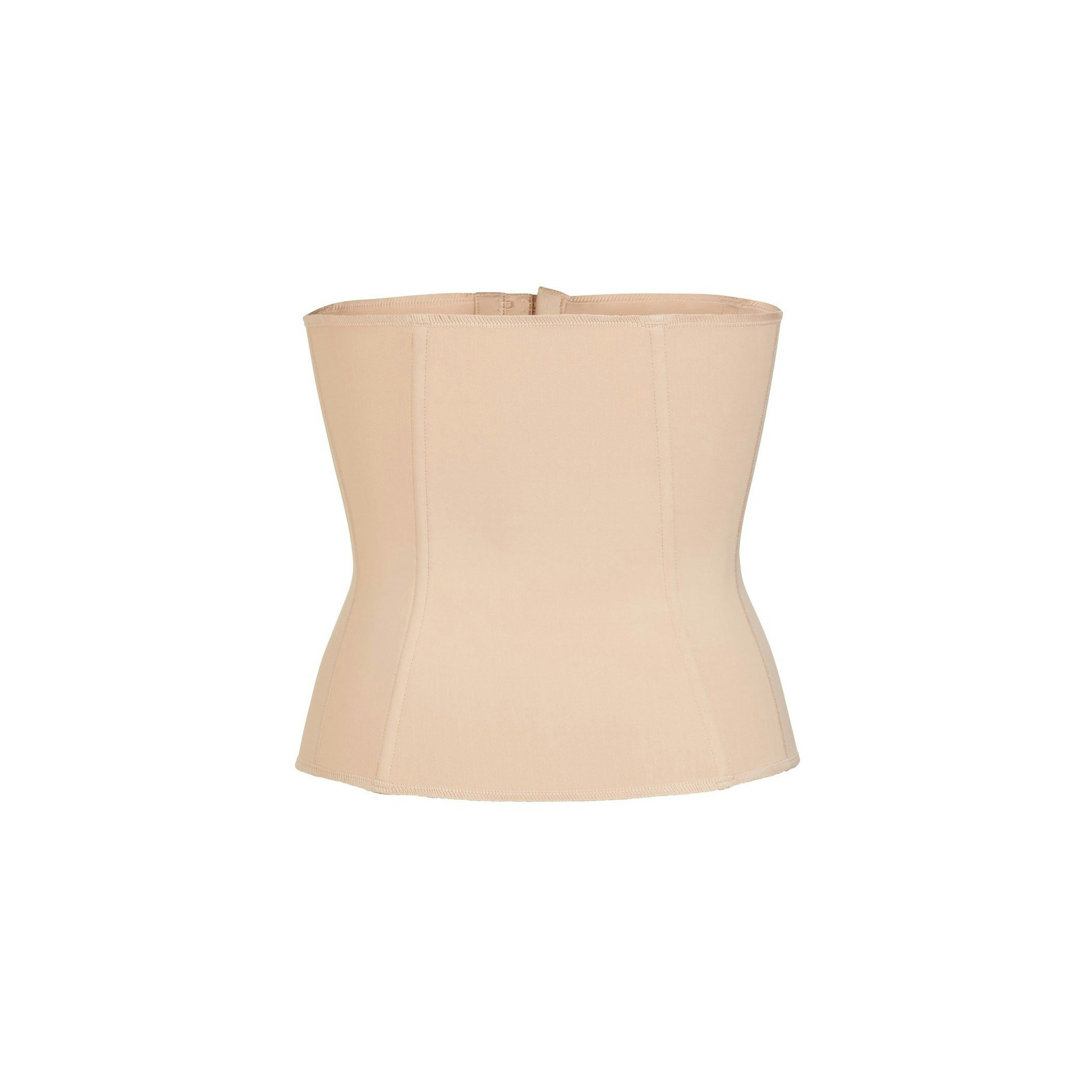 A MODEL STANDS FACING FORWARD WEARING THE WAIST TRAINER | CLAY