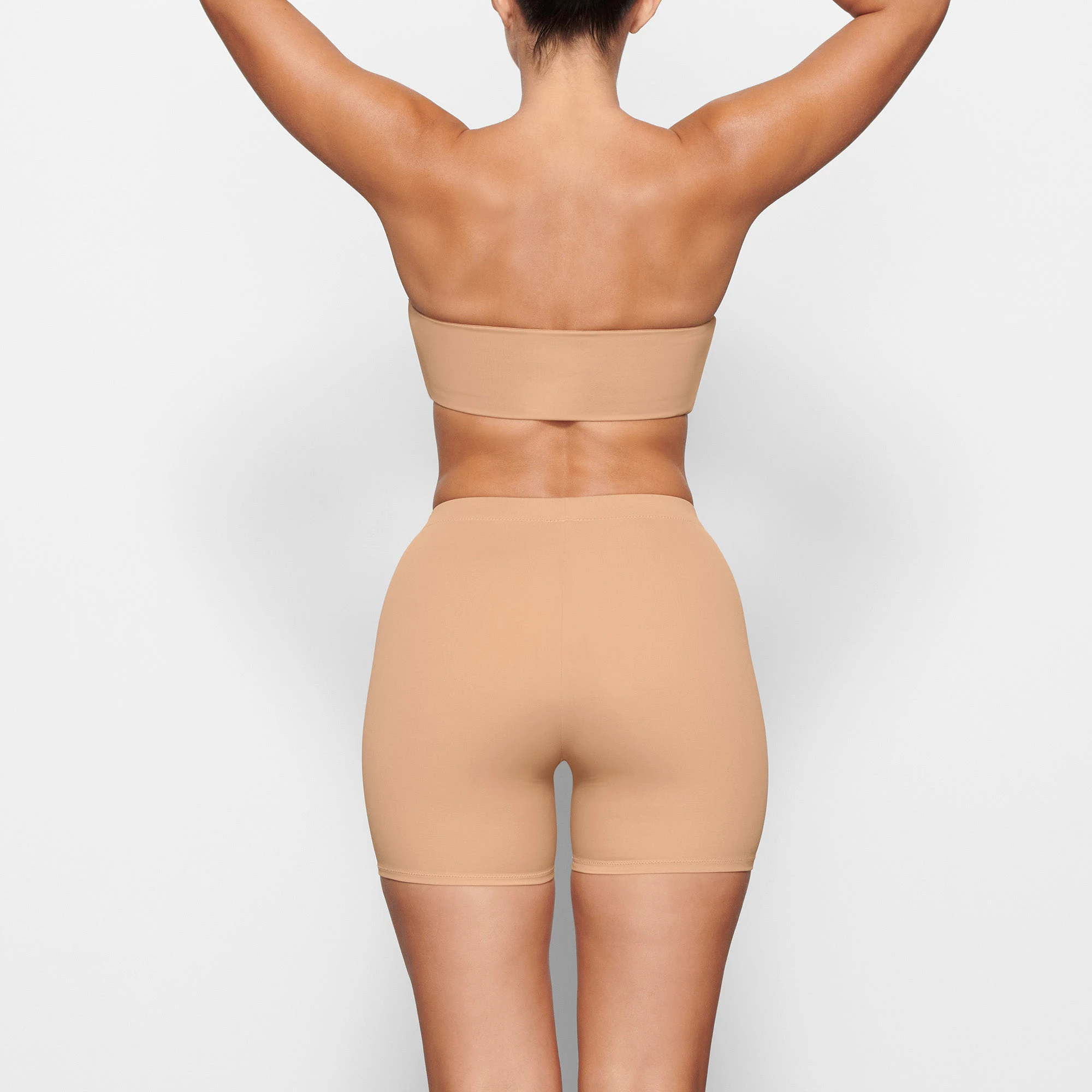 SWIM MID WAIST SHORTS WORN BY A MODEL IN BACK VIEW