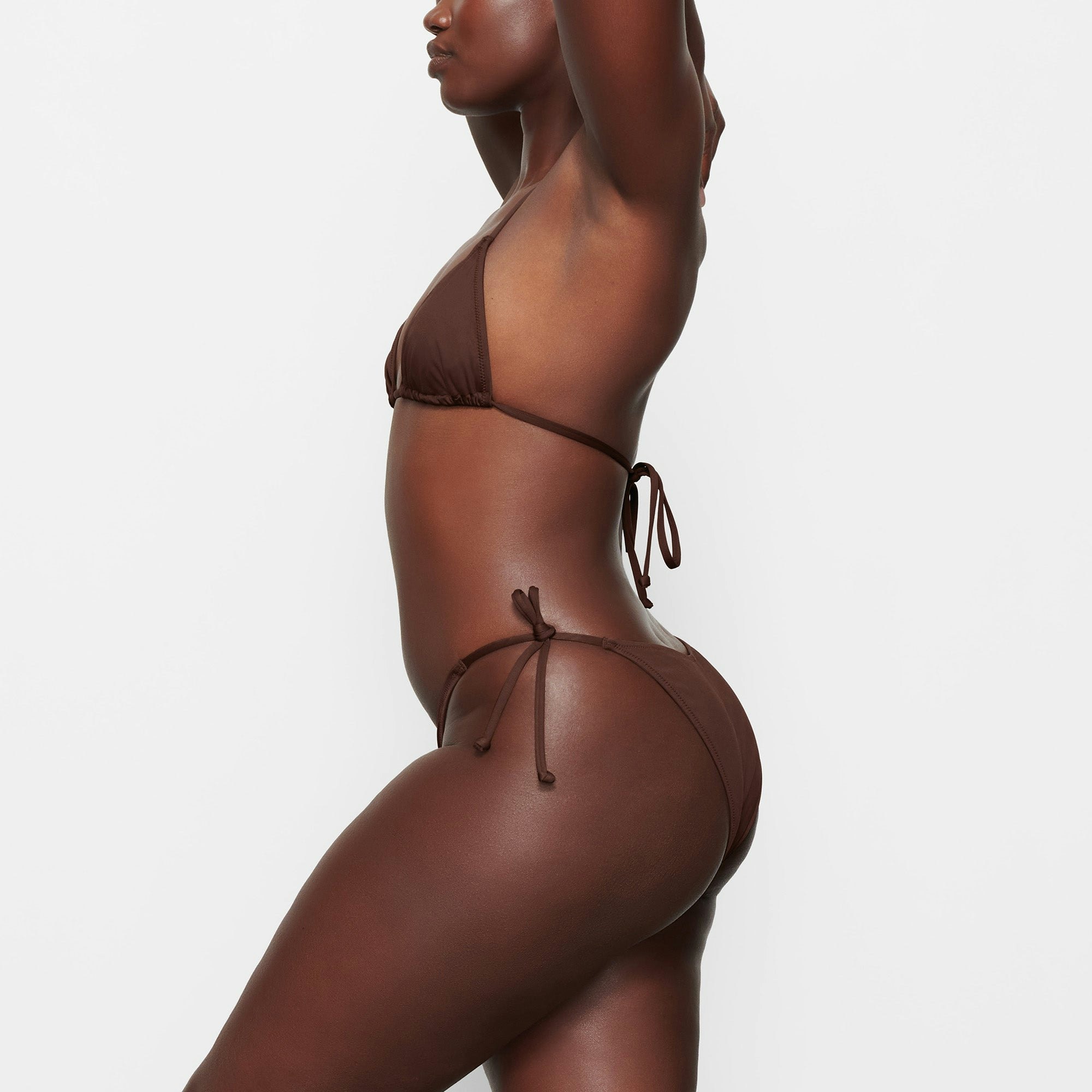 SWIM TRIANGLE TOP WORN BY A MODEL IN SIDE VIEW