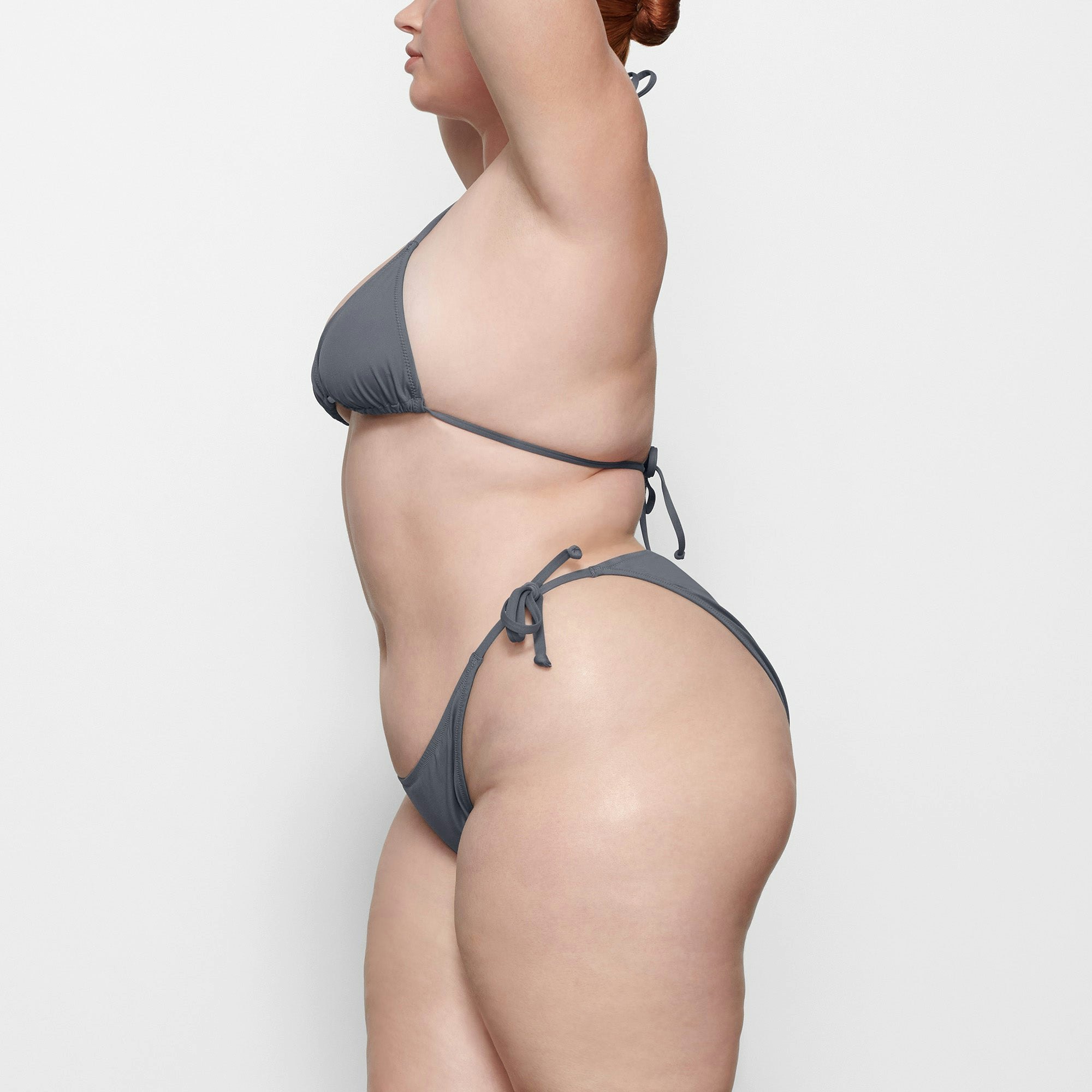 SWIM TRIANGLE TOP WORN BY A MODEL IN SIDE VIEW