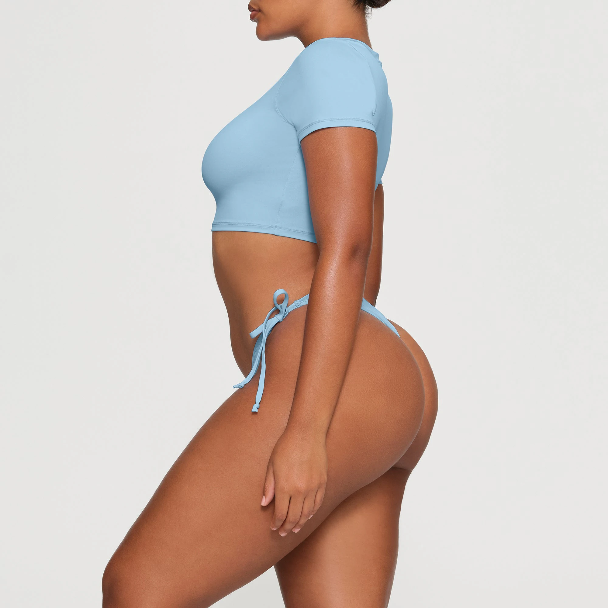 SWIM T-SHIRT WORN BY A MODEL IN SIDE VIEW