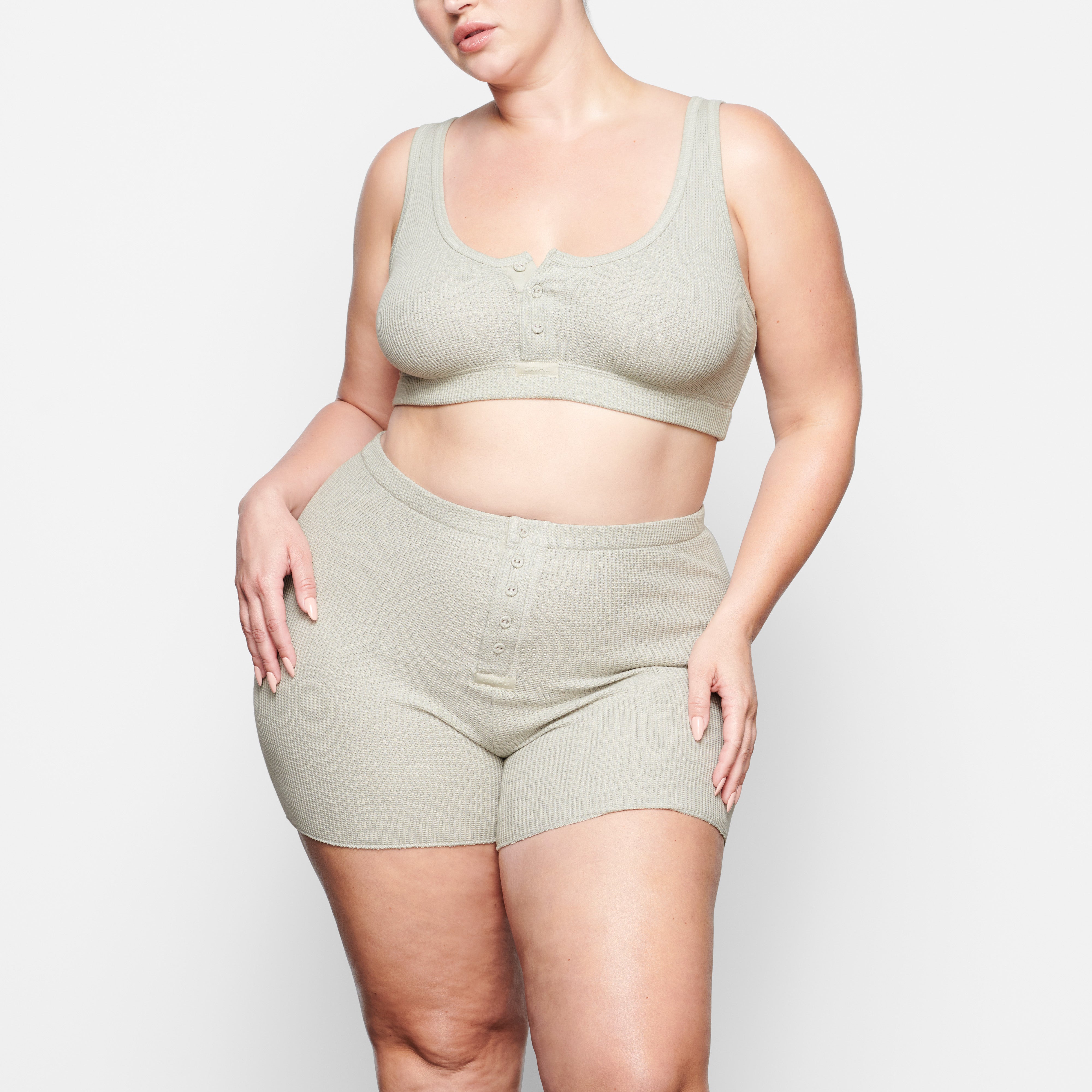 A MODEL STANDS FACING FORWARD WEARING THE SKIMS WAFFLE SHORT IN TALC | SEE: 2X, 3X, 4X